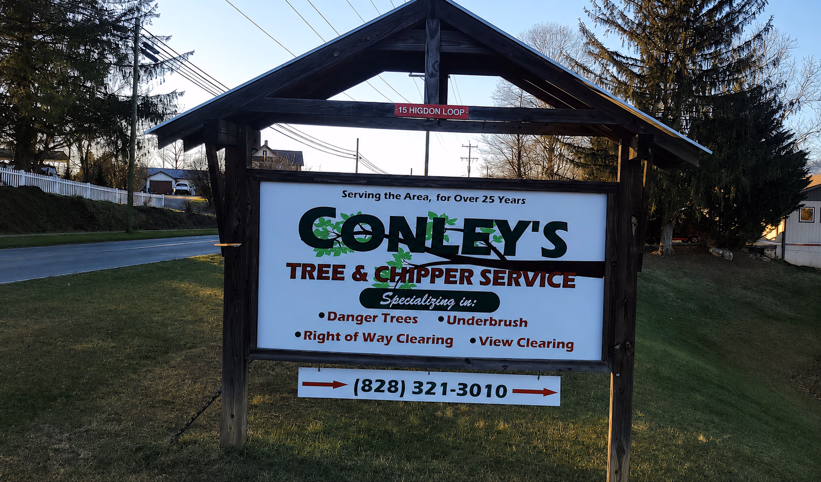 Outdoor sign for Conley's Tree & Chipper Service specializing in danger trees, underbrush, clearing, with phone number.